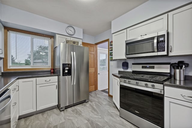 7812 Wieneke Cir, Cedar Rapids, IA 52404 - kitchen with stainless steel appliances, plenty of natural light, dark countertops, and white cabinetry