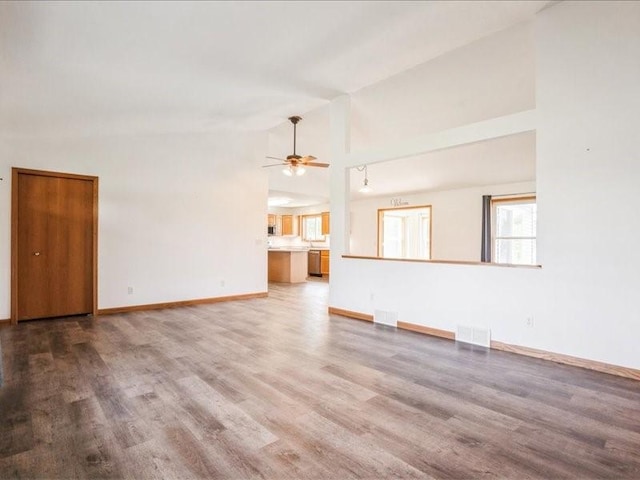 3182 62nd St, Shellsburg, IA 52332 - unfurnished living room with a ceiling fan, wood finished floors, and high vaulted ceiling