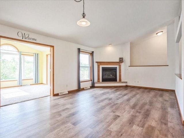 3182 62nd St, Shellsburg, IA 52332 - unfurnished living room with wood finished floors and a glass covered fireplace