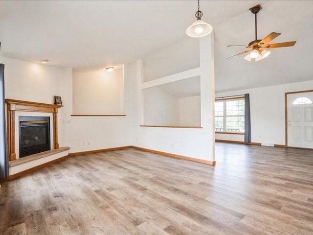 3182 62nd St, Shellsburg, IA 52332 - unfurnished living room with wood finished floors, a glass covered fireplace, lofted ceiling, and ceiling fan