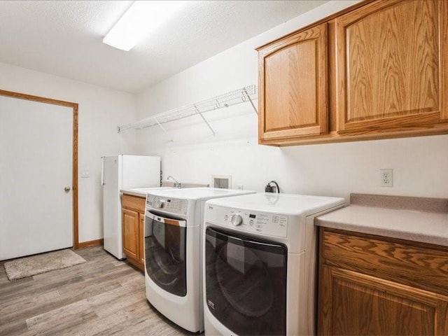 3182 62nd St, Shellsburg, IA 52332 - laundry room with cabinet space, light wood finished floors, and washer and dryer