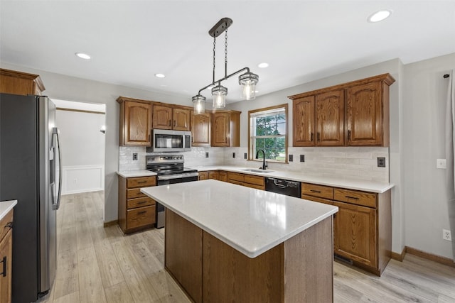 7603 Hampshire Dr NE, Cedar Rapids, IA 52402 - kitchen featuring stainless steel appliances, light wood-style floors, a kitchen island, decorative backsplash, and brown cabinets