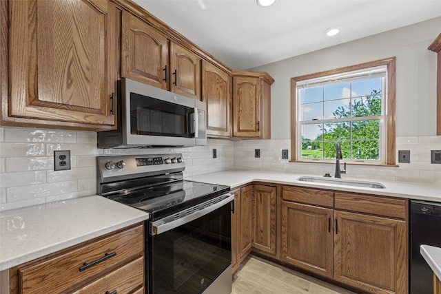 7603 Hampshire Dr NE, Cedar Rapids, IA 52402 - kitchen with appliances with stainless steel finishes, brown cabinetry, decorative backsplash, and recessed lighting