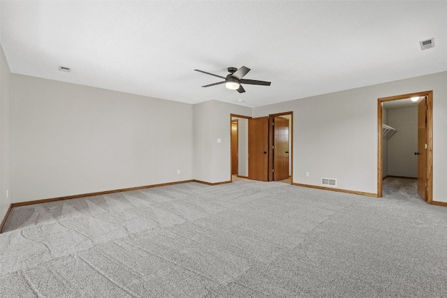 7603 Hampshire Dr NE, Cedar Rapids, IA 52402 - unfurnished bedroom with light colored carpet, a walk in closet, and a ceiling fan