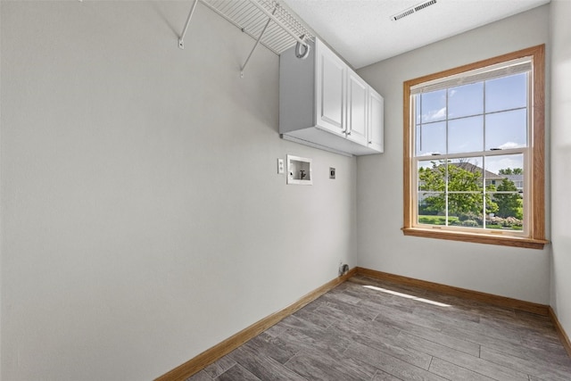 7603 Hampshire Dr NE, Cedar Rapids, IA 52402 - washroom with cabinet space, hookup for an electric dryer, washer hookup, and wood finished floors