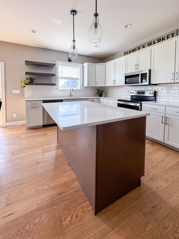 509 Grey Slate Dr SW, Cedar Rapids, IA 52404 - kitchen featuring stainless steel appliances, a center island, tasteful backsplash, light countertops, and hanging light fixtures