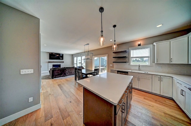 509 Grey Slate Dr SW, Cedar Rapids, IA 52404 - kitchen with a fireplace, open floor plan, light countertops, pendant lighting, and decorative backsplash