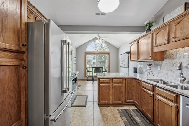 4725 Westchester Dr NE Unit C, Cedar Rapids, IA 52402 - kitchen featuring appliances with stainless steel finishes, a peninsula, a ceiling fan, lofted ceiling, and brown cabinets