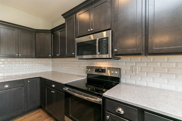 806 Crestview Dr, Solon, IA 52333 - kitchen with appliances with stainless steel finishes, light wood-style floors, decorative backsplash, and dark brown cabinets