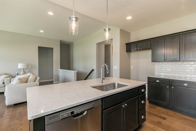 806 Crestview Dr, Solon, IA 52333 - kitchen featuring stainless steel dishwasher, wood finished floors, backsplash, a center island with sink, and hanging light fixtures