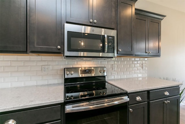806 Crestview Dr, Solon, IA 52333 - kitchen featuring stainless steel appliances, tasteful backsplash, and light stone counters
