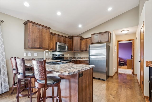 1301 Scarlet Sage Dr SW, Cedar Rapids, IA 52404 - kitchen with stainless steel appliances, vaulted ceiling, a peninsula, light wood-type flooring, and recessed lighting
