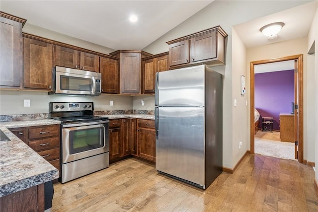 1301 Scarlet Sage Dr SW, Cedar Rapids, IA 52404 - kitchen featuring appliances with stainless steel finishes, light wood-type flooring, lofted ceiling, light countertops, and dark brown cabinets