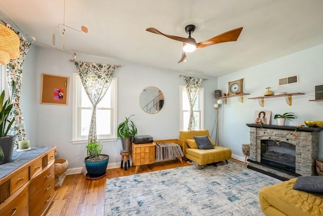 1120 23rd St, Cedar Rapids, IA 52403 - living area with ceiling fan, light wood-style floors, and a fireplace