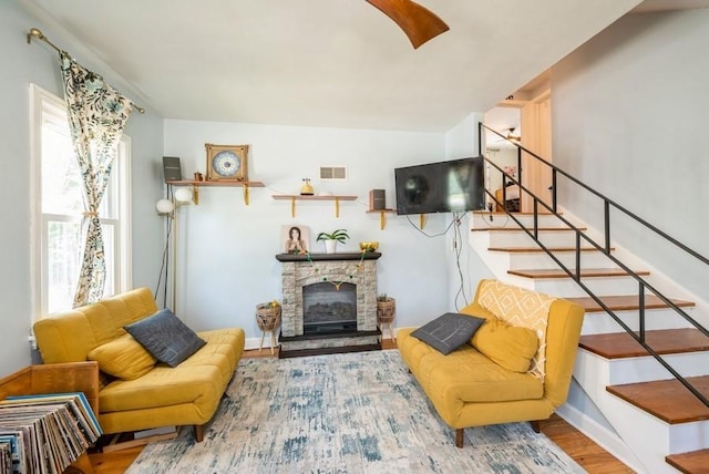 1120 23rd St, Cedar Rapids, IA 52403 - living area featuring wood finished floors, stairway, and a stone fireplace