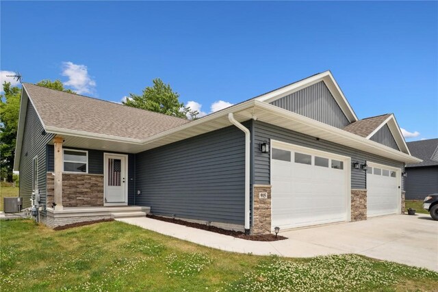 915 Prairie View Dr, West Branch, IA 52358 - view of front facade featuring a garage, driveway, stone siding, roof with shingles, and board and batten siding