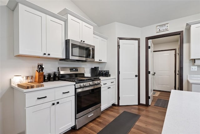 915 Prairie View Dr, West Branch, IA 52358 - kitchen featuring appliances with stainless steel finishes, light countertops, dark wood-style flooring, white cabinetry, and lofted ceiling