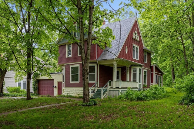 320 College Blvd SW, Mount Vernon, IA 52314 - view of front facade featuring covered porch, a garage, a front lawn, and a shingled roof