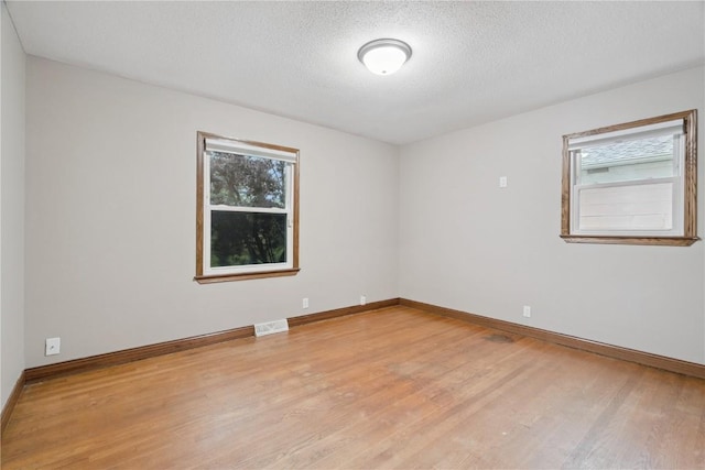 5315 E Ave NW, Cedar Rapids, IA 52405 - spare room featuring light wood-style floors, plenty of natural light, and a textured ceiling