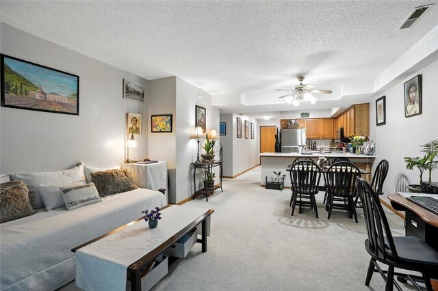 414 W Side Dr, Iowa City, IA 52246 - living room with a textured ceiling, light colored carpet, and a ceiling fan