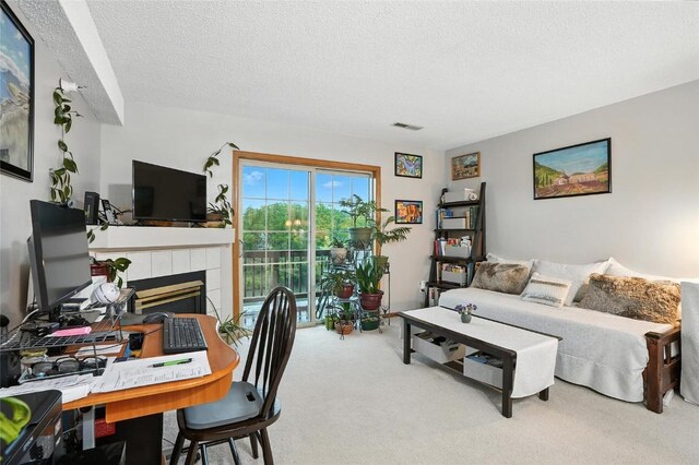 414 W Side Dr, Iowa City, IA 52246 - living area featuring carpet flooring, a tile fireplace, and a textured ceiling