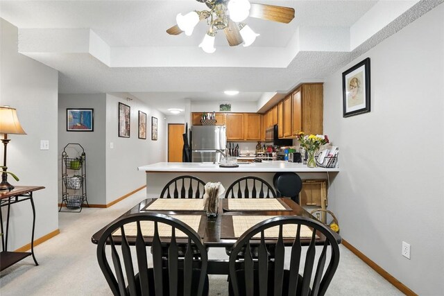 414 W Side Dr, Iowa City, IA 52246 - dining space featuring a raised ceiling, light colored carpet, and a ceiling fan