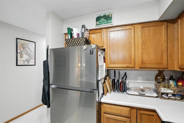 414 W Side Dr, Iowa City, IA 52246 - kitchen with freestanding refrigerator, light countertops, and brown cabinetry