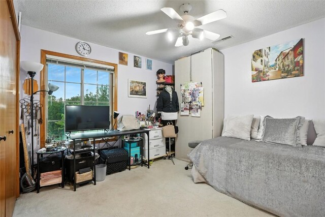 414 W Side Dr, Iowa City, IA 52246 - bedroom with an office area, carpet flooring, a textured ceiling, and a ceiling fan