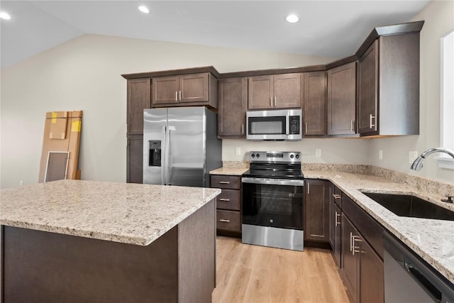 3880 Quail Trail Dr, Marion, IA 52302 - kitchen featuring appliances with stainless steel finishes, lofted ceiling, dark brown cabinetry, light wood-style floors, and light stone countertops