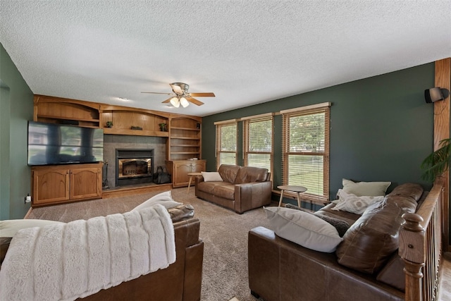 1720 Charleston Dr, Marion, IA 52302 - living room featuring a ceiling fan, a textured ceiling, carpet flooring, and a glass covered fireplace