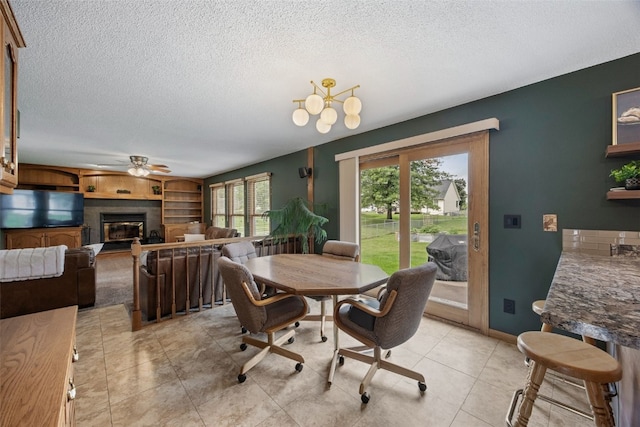 1720 Charleston Dr, Marion, IA 52302 - dining area with a textured ceiling, a glass covered fireplace, a ceiling fan, light tile patterned flooring, and built in features