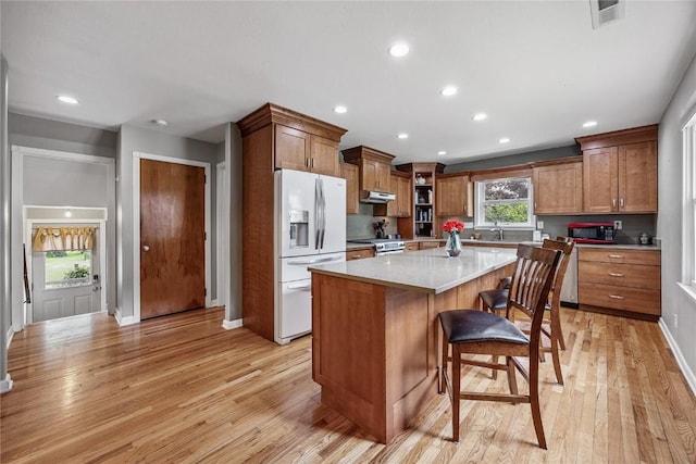 115 3rd St NE, Mount Vernon, IA 52314 - kitchen with appliances with stainless steel finishes, light wood finished floors, brown cabinetry, and recessed lighting