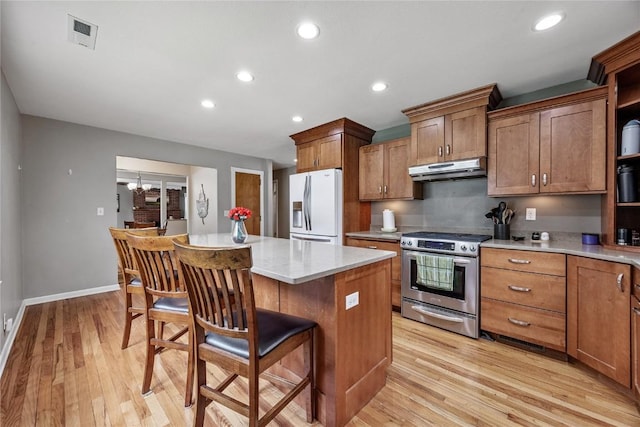 115 3rd St NE, Mount Vernon, IA 52314 - kitchen with white refrigerator with ice dispenser, stainless steel stove, open shelves, under cabinet range hood, and a breakfast bar area