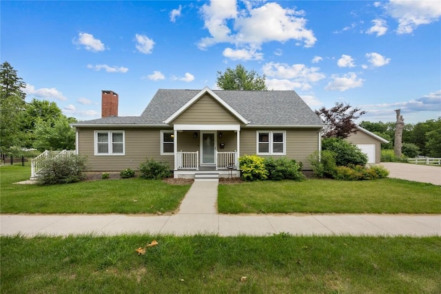 115 3rd St NE, Mount Vernon, IA 52314 - bungalow-style home featuring covered porch, a chimney, a front lawn, and a garage