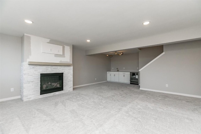 5750 Meadow Grass Cir SE, Cedar Rapids, IA 52403 - unfurnished living room with carpet floors, a stone fireplace, and recessed lighting