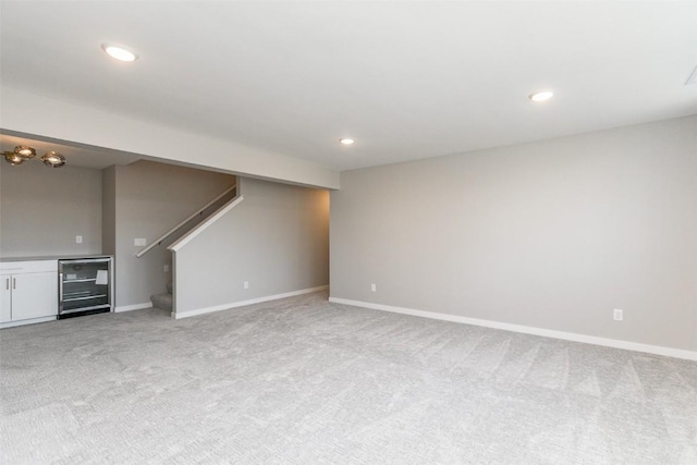 5750 Meadow Grass Cir SE, Cedar Rapids, IA 52403 - unfurnished living room with wine cooler, light colored carpet, stairs, recessed lighting, and bar