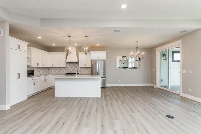 5750 Meadow Grass Cir SE, Cedar Rapids, IA 52403 - kitchen with freestanding refrigerator, premium range hood, a chandelier, light countertops, and backsplash