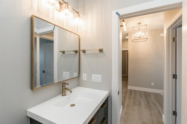 5750 Meadow Grass Cir SE, Cedar Rapids, IA 52403 - bathroom with wood finished floors, a chandelier, and vanity