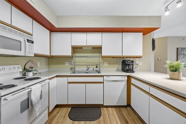 2861 Coral Ct Unit 302, Coralville, IA 52241 - kitchen featuring white appliances, white cabinetry, light wood-style floors, light countertops, and a textured ceiling