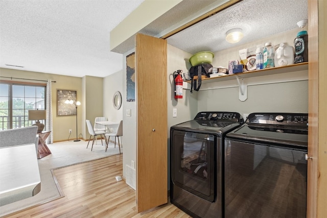 2861 Coral Ct Unit 302, Coralville, IA 52241 - laundry room featuring washer and clothes dryer, a textured ceiling, and light wood finished floors
