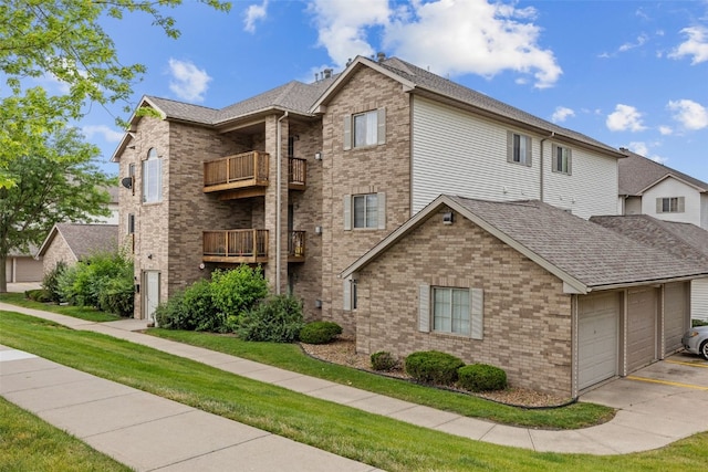 2861 Coral Ct Unit 302, Coralville, IA 52241 - view of front of home featuring a balcony, brick siding, concrete driveway, and a front yard