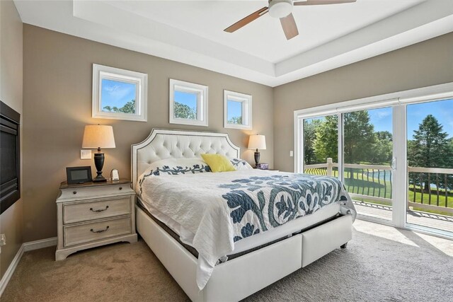 701 Sherwood Dr, Iowa City, IA 52245 - carpeted bedroom with access to exterior, a raised ceiling, and ceiling fan