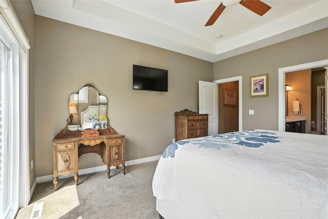 701 Sherwood Dr, Iowa City, IA 52245 - bedroom with light colored carpet, a raised ceiling, ensuite bath, and ceiling fan