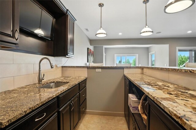701 Sherwood Dr, Iowa City, IA 52245 - kitchen featuring light stone counters, backsplash, recessed lighting, hanging light fixtures, and light tile patterned floors