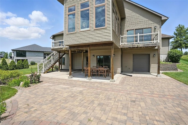 701 Sherwood Dr, Iowa City, IA 52245 - view of front of property featuring stairs, a garage, decorative driveway, a balcony, and a patio area