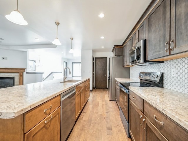 3502 Bluebird Dr SW, Cedar Rapids, IA 52404 - kitchen with appliances with stainless steel finishes, light wood-style floors, backsplash, pendant lighting, and recessed lighting
