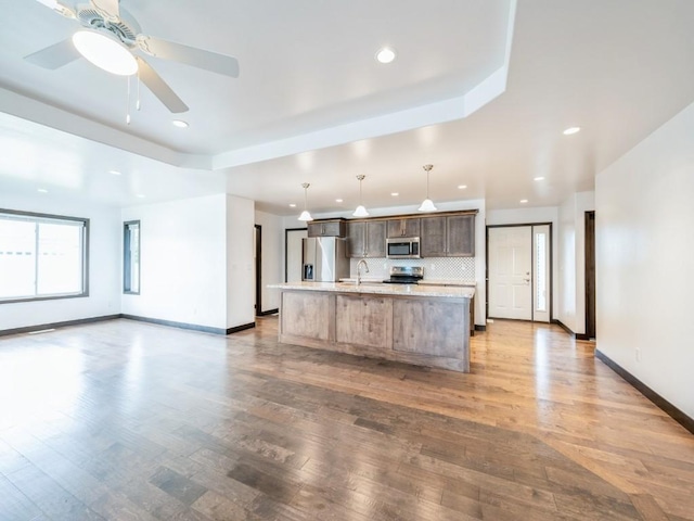 3502 Bluebird Dr SW, Cedar Rapids, IA 52404 - kitchen with appliances with stainless steel finishes, light countertops, a center island with sink, open floor plan, and recessed lighting