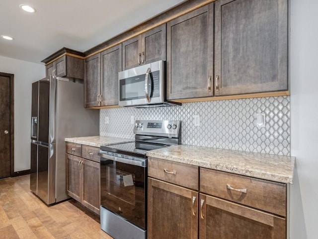 3502 Bluebird Dr SW, Cedar Rapids, IA 52404 - kitchen featuring stainless steel appliances, light wood-style flooring, tasteful backsplash, recessed lighting, and dark brown cabinets