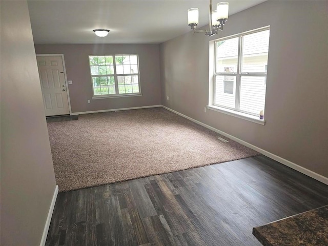 441 8th Ave SW, Cedar Rapids, IA 52404 - unfurnished room with dark wood-style floors and a chandelier