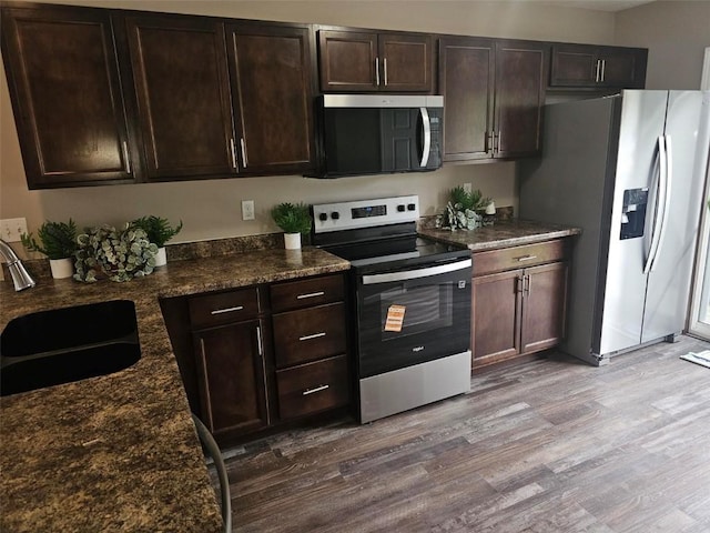 441 8th Ave SW, Cedar Rapids, IA 52404 - kitchen featuring appliances with stainless steel finishes, wood finished floors, and dark brown cabinets
